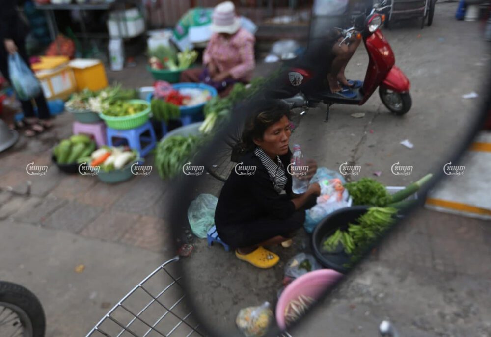 អ្នកលក់បន្លែអង្គុយលក់នៅលើចិញ្ចើមផ្លូវ នៅជាយក្រុងភ្នំពេញ កាលពីថ្ងៃទី១១ ខែកម្ភៈ។ ព្រីង សំរាំង