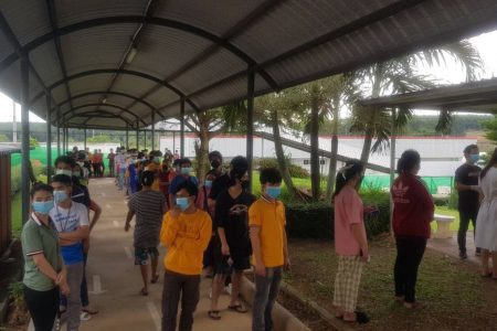 ពលករខ្មែរនៅក្នុងរោងចក្រកែច្នៃសាច់មាន់GFN ក្នុងខេត្តឈុនបុរី ប្រទេសថៃ កំពុងឈររង់ចាំយកសំណាកពិនិត្យរកមេរោគកូវីដ-១៩ នៅថ្ងៃទី១៧ ខែមេសា ឆ្នាំ២០២១។ រូបភាពផ្តល់ឱ្យ