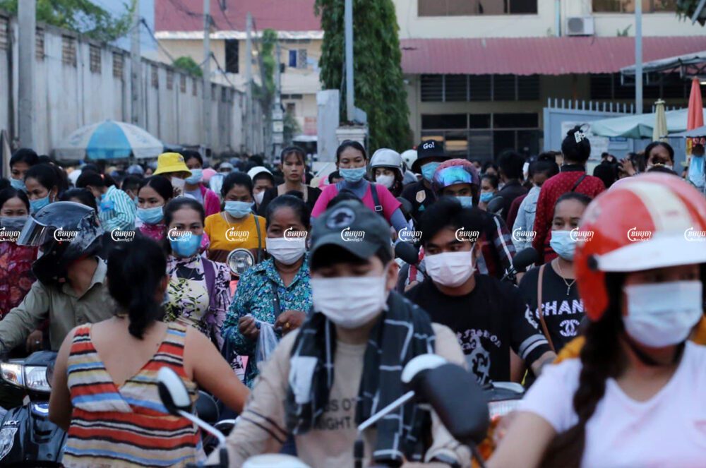 កម្មករចេញពីរោងចក្រមួយនៅជាយក្រុងភ្នំពេញក្រោយចប់ម៉ោងការងារ រូបភាពថតកាលពីថ្ងៃទី១៨ ខែសីហា ឆ្នាំ២០២១។ ខេមបូចា/បញ្ញា ឆព័ណ្ណ