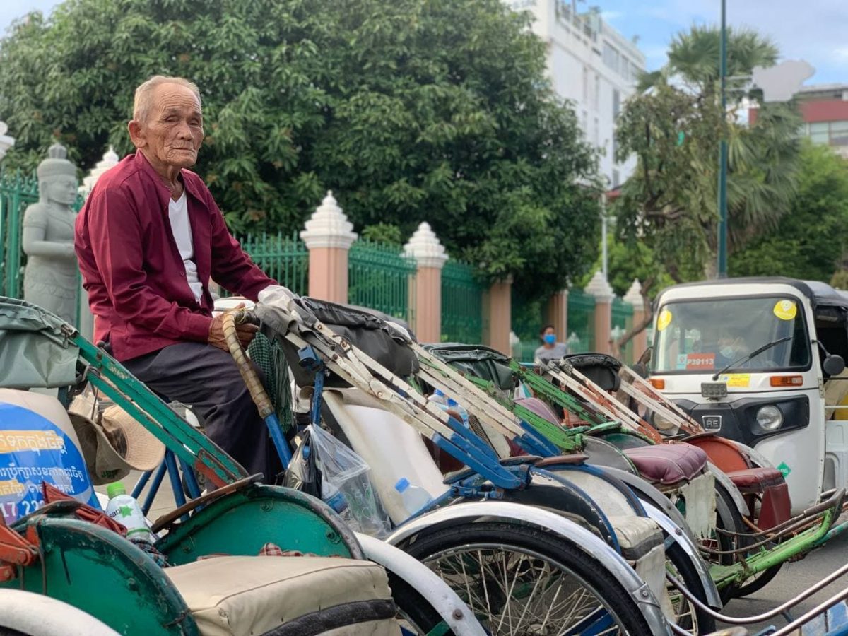 លោក ងួន សុខ អង្គុយលើស៊ីក្លូក្បែរមាត់ទន្លេ ជាកន្លែងដែលលោករង់ចាំហៅភ្ញៀវជិះស៊ីក្លូ ក្នុងរាជធានីភ្នំពេញ។ រូបភាពថត កាលពីថ្ងៃទី២១ ខែកញ្ញា ឆ្នាំ២០២១។ ខេមបូខា/ ម៉ន វុទ្ធា