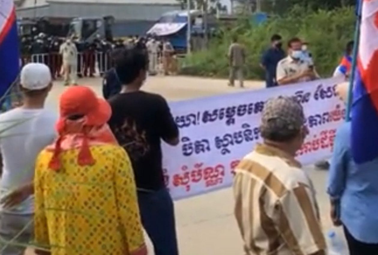 អ្នកភូមិធ្វើបាតុកម្មទាមទារប័ណ្ណកម្មសិទ្ធិដីនៅជិតការិយាល័យនៃក្រសួងរៀបចំដែនដី ខណៈលោកនាយករដ្ឋមន្ត្រី ហ៊ុន សែន ថ្លែងក្នុងពិធីសម្ពោធអគារថ្មីរបស់ក្រសួង នៅរាជធានីភ្នំពេញ កាលពីថ្ងៃទី៨ ខែវិច្ឆិកា ឆ្នាំ២០២១។ រូមភាពពីហ្វេសប៊ុក