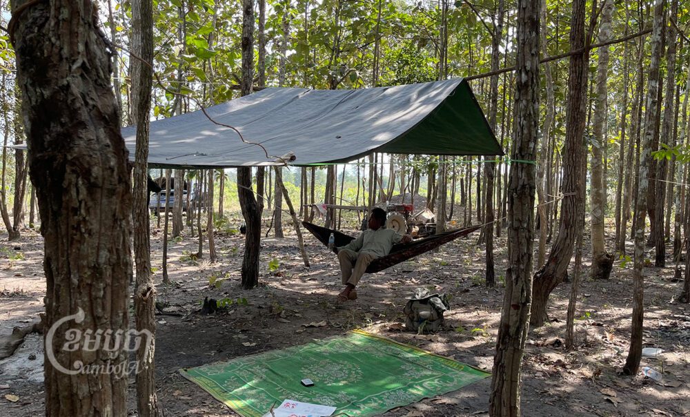 អ្នកភូមិម្នាក់អង្គុយក្នុងអង្រឹងសម្រាកពីការដើរល្បាតដីព្រៃសហគមន៍ក្នុងស្រុកឱរ៉ាល់ ខេត្តកំពង់ស្ពឺ។ រូបថតថ្ងៃទី១៧ ខែមករា ឆ្នាំ២០២២។ ខេមបូចា/ ស៊ន សារ៉ាត