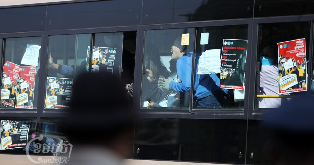 បុគ្គលិកក្រុមហ៊ុនណាហ្គាវើលដ៍ស្រែកសុំឲ្យជួយ ខណៈអាជ្ញាធរបង្ខំឲ្យពួកគេចូលក្នុងឡានក្រុងមួយ។ ប៉ូលិសនិងមន្រ្តីដទៃទៀតបានឃុំខ្លួនក្រុមនយោជិតនេះ ស្របពេលពួកគេវិលត្រឡប់មកធ្វើកូដកម្មឡើងវិញក្បែរអគារក្រុមហ៊ុនកាស៊ីណូណាហ្គាវើលដ៍ ក្នុងរាជធានីភ្នំពេញ កាលពីថ្ងៃទី២១ ខែកុម្ភៈ ឆ្នាំ២០២២។ ខេមបូចា/ ព្រីង សំរាំង