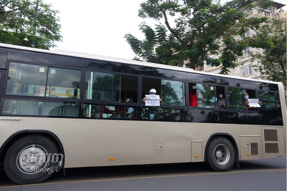 កូដករក្រុមហ៊ុនណាហ្គាវើលដ៍ស្រែកសុំឲ្យជួយ ខណៈអាជ្ញាធរបានចាប់ខ្លួនពួកគេដាក់ចូលក្នុងឡានក្រុង នៅពេលដែលពួកគេព្យាយាមទៅធ្វើកូដកម្មនៅមុខសណ្ឋាគារ និងកាស៊ីណូណាហ្គាវើលដ៍ ក្នុងរាជធានីភ្នំពេញ។ រូបថតនៅថ្ងៃទី២០ ខែមេសា ឆ្នាំ២០២២។ ខេមបូចា/ព្រីង សំរាំង