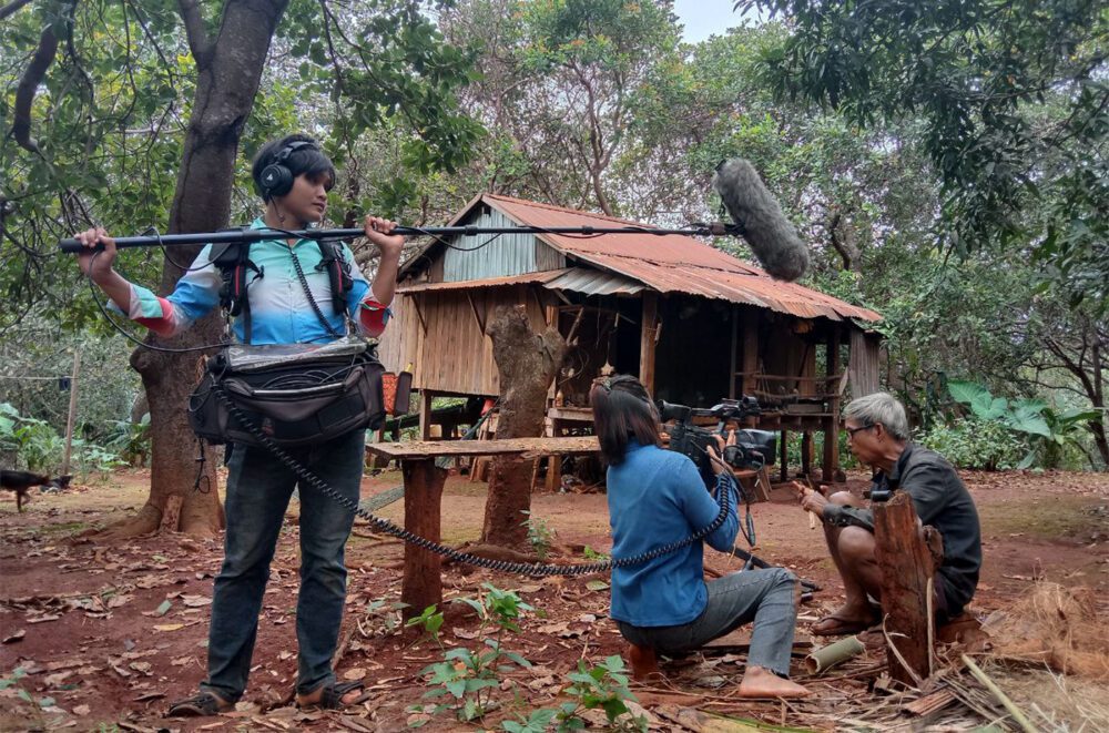 កញ្ញា ចេន សុជាតា និងក្រុមការងារបស់នាងថតបុរសម្នាក់ដែលកំពុងកាត់ឬស្សីសម្រាប់ធ្វើទ្រឃ្លោក នៅក្នុងខេត្តរតនគិរី កាលពីខែតុលា ឆ្នាំ២០២១។ រូបភាពផ្តល់ឲ្យ