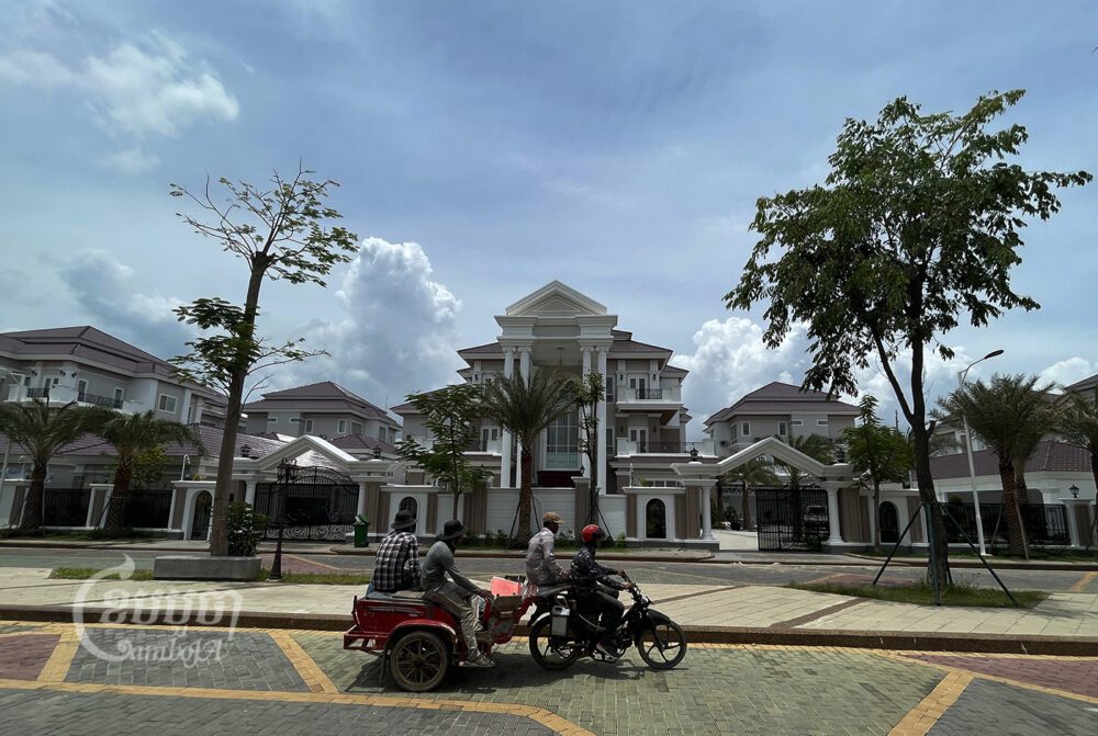 កម្មករជិះកាត់វីឡាថ្លៃៗនៅក្នុងរាជធានីភ្នំពេញ។ រូបថតថ្ងៃទី១២ ខែឧសភា ឆ្នាំ២០២២។ ខេមបូចា/ ព្រីង សំរាំង