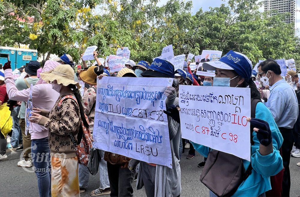 កូដករកំពុងលើកបដាទាមទារឱ្យក្រុមហ៊ុនណាហ្គាវើលដ៍ដោះស្រាយវិវាទនិងគោរពច្បាប់ការងារ។ រូបថតថ្ងៃទី៥ ខែកក្កដា ឆ្នាំ២០២២។ ខេមបូចា/ សុវណ្ណ ស្រីពេជ្រ