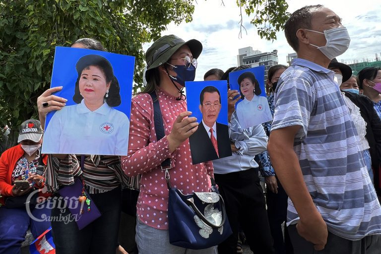 អាជីវករផ្សារអូរឫស្សីកាន់រូបថតលោកនាយករដ្ឋមន្រ្តីនិងសម្ដេចគតិព្រឹត្តិបណ្ឌិត ខណៈពួកគេទៅដាក់ញត្តិដើម្បីសុំអន្តរាគមន៍ឱ្យបញ្ចុះតម្លៃតូប រាជធានីភ្នំពេញ។ រូបថតថ្ងៃទី១៥ ខែសីហា ឆ្នាំ២០២២។ ខេមបូចា/ សុវណ្ណ ស្រីពេជ្រ