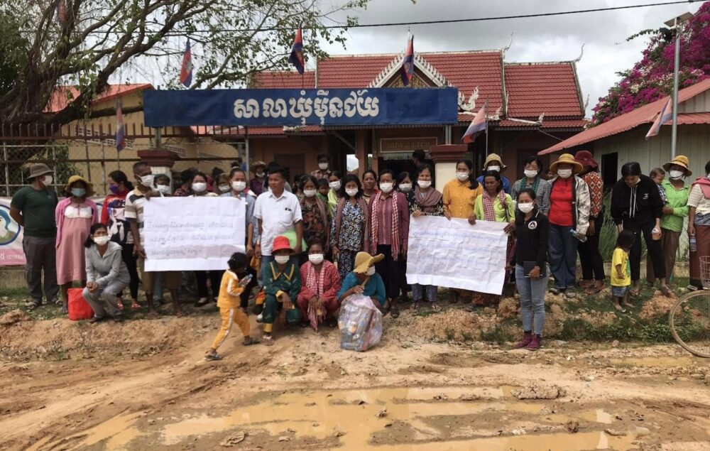 ពលរដ្ឋទាំង២ឃុំឈរលើកបដានៅមុខសាលាឃុំម៉ឺនជ័យ ស្រុករំដួល ខេត្តស្វាយរៀង ដើម្បីស្នើអាជ្ញាធរមូលដ្ឋានជួយដោះស្រាយ។ រូបថតនៅថ្ងៃទី៧ ខែកញ្ញា ឆ្នាំ២០២២។ រូបភាពផ្តល់ឱ្យ