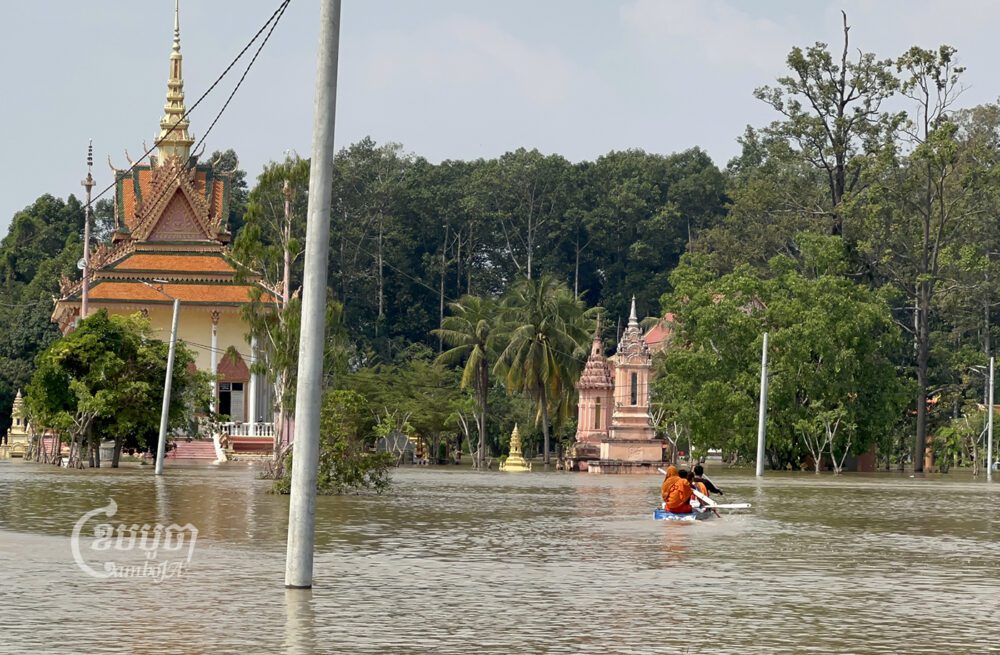 ព្រះសង្ឃចែវទូកនៅក្នុងវត្ត ខណៈជន់លិចដោយជំនន់ទឹកភ្លៀងខុសរដូវ នៅសង្កាត់ព្រែកជ្រៃ ជាយក្រុងភ្នំពេញ។ រូបថតថ្ងៃទី១៦ ខែមករា ឆ្នាំ២០២៣។ ខេមបូចា/ សុវណ្ណ ស្រីពេជ្រ