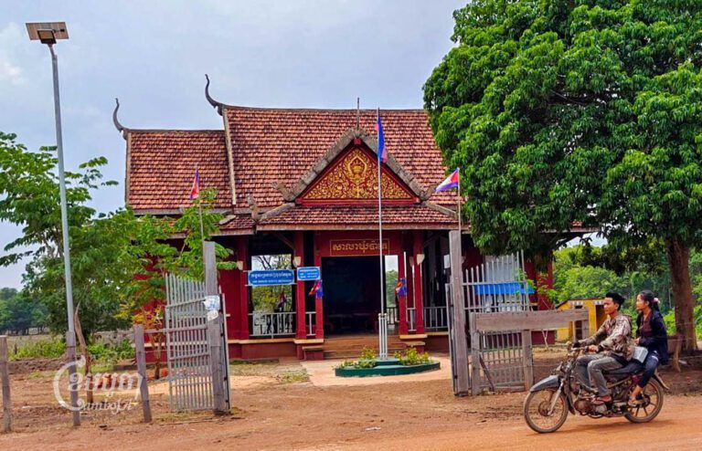 ពលរដ្ឋ២នាក់កំពុងជិះម៉ូតូឆ្លងកាត់មុខសាលាឃុំប៉ាតេ ស្រុកអូរយ៉ាដាវ ខេត្តរតនគិរី។ រូបថតនៅថ្ងៃទី២៤ ខែឧសភា ឆ្នាំ២០២៣។ ខេមបូចា/ បញ្ញា ឆព័ណ្ណ