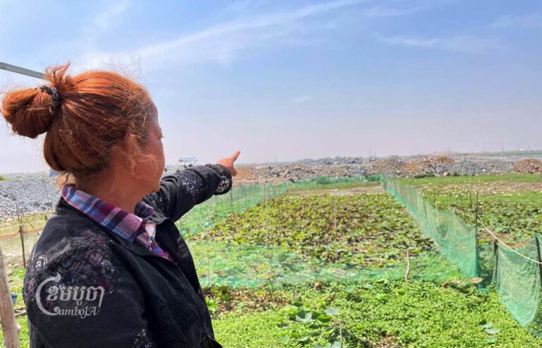 អ្នកស្រី ប្រាក់ សុភា ចង្អុលប្រាប់ទីតាំងគេចាក់ដីទៅក្នុងបឹងនៅខាងក្រោយផ្ទះអ្នកស្រីកាលពីថ្ងៃទី២៥ ខែកុម្ភៈ ឆ្នាំ២០២៣។(ខេមបូចា/ ផុន សុទ្ធីរ័ត្ន)