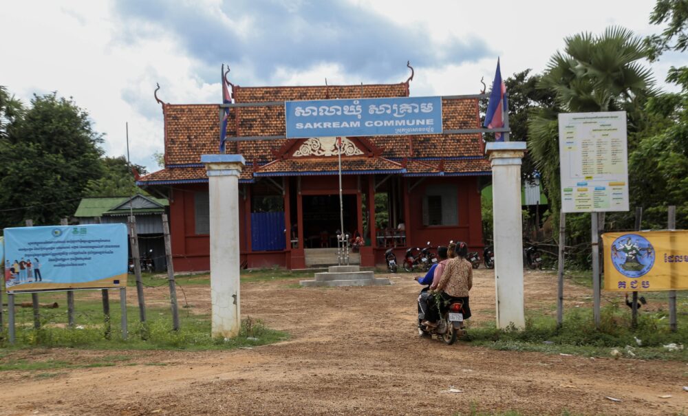 ប្រជាពលរដ្ឋកំពុងជិះម៉ូតូឌុបគ្នាចូលបរិវេណសាលាឃុំសាគ្រាម ស្រុកប្រាសាទបល្ល័ង្ក ខេត្តកំពង់ធំ ដើម្បីរកសាវាសាធារណៈ។ រូបថតនៅថ្ងៃទី២៥ ខែកញ្ញា ឆ្នាំ២០២៣។ (រូបថត៖ អាន វិចិត្រ)