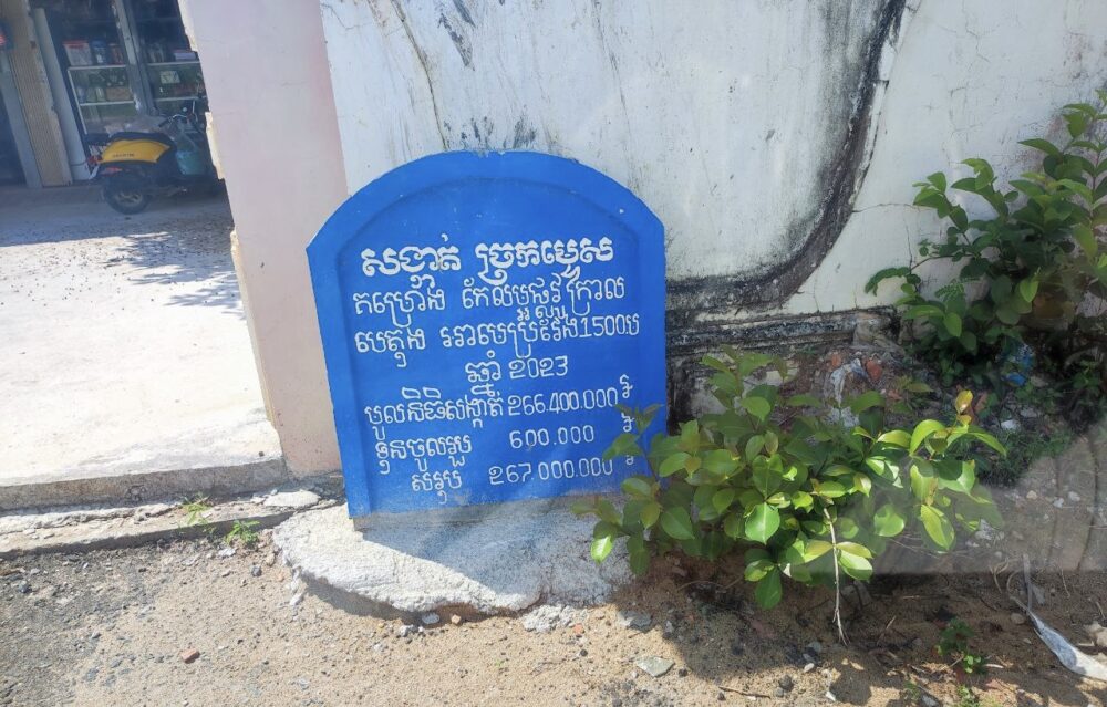 ផ្ទាំងព័ត៌មានបង្ហាញពីគម្រោងអភិវឌ្ឍន៍កែលម្អរផ្លូវក្រាលបេតុង នៅភូមិកំពោតប្រស់ សង្កាត់ច្រកម្ទេស ក្រុងបាវិត។ រូបថតនៅថ្ងៃទី២៨ ខែតុលា ឆ្នាំ២០២៣។ (រូបថត៖ វណ្ណ វិចារ)