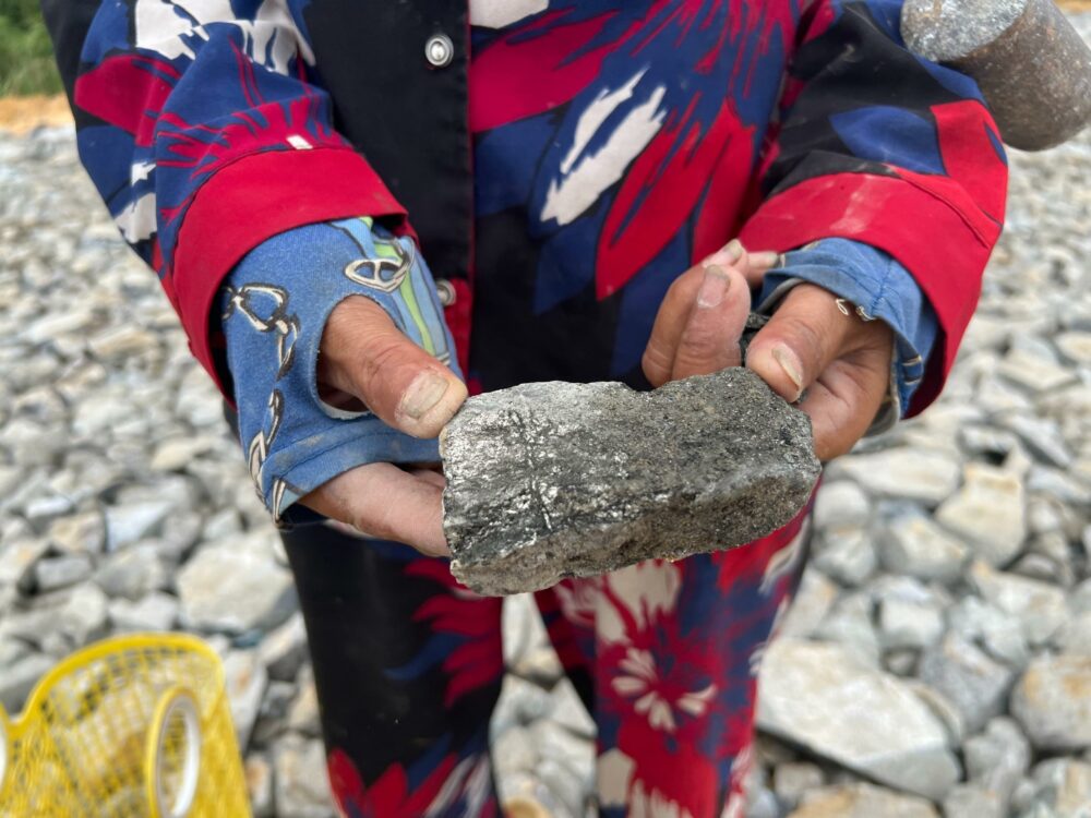 អ្នកភូមិកាន់សំណល់រ៉ែមួយដុំដែលបន្សល់ទុកដោយក្រុមហ៊ុនជីករ៉ែមាសនៅក្នុងខេត្តក្រចេះ នៅក្នុងឆ្នាំ២០២៣ ។ (អង្គការ សមធម៌កម្ពុជា)