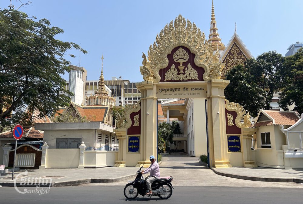បុរសម្នាក់ជិះម៉ូតូកាត់មុខក្រសួងធម្មការ និងសាសនា ក្នុងរាជធានីភ្នំពេញ នៅថ្ងៃទី១៤ ខែកុម្ភៈ ឆ្នាំ២០២៤។ (ខេមបូចា / ព្រីង សំរាំង)