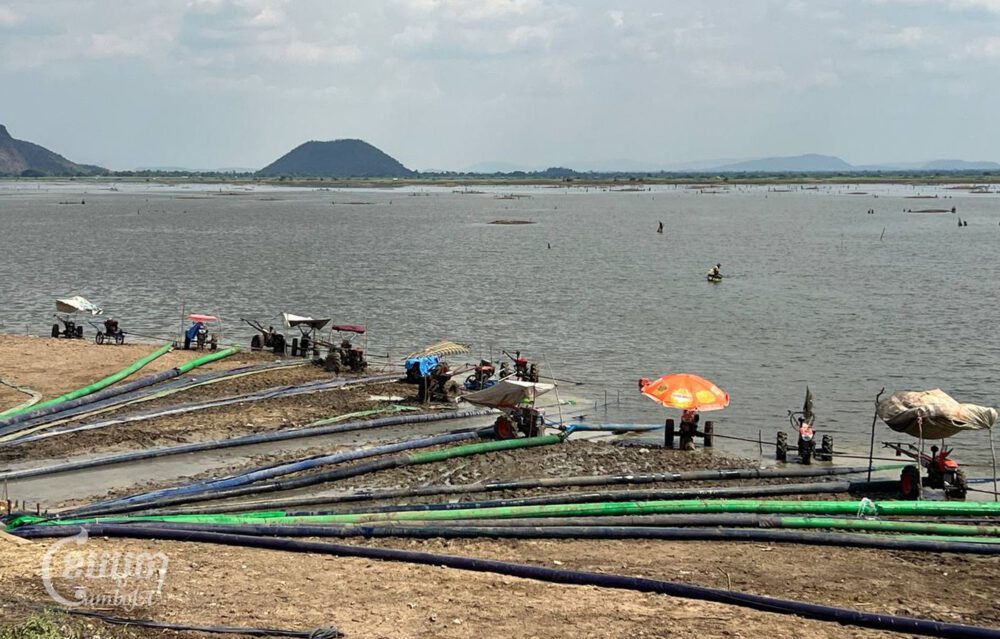 ប្រជាពលរដ្ឋនាំគ្នាយកគោយន្តបូមទឹកពីទំនប់កំពីងពួយដើម្បីស្រោចស្រពស្រូវប្រាំងរបស់ពួកគាត់នៅក្រោមអាង។ រូបថតនៅថ្ងៃទី២៧ ខែមេសា ឆ្នាំ២០២៤។ (ខេមបូចា/ មាស ភារុណ)