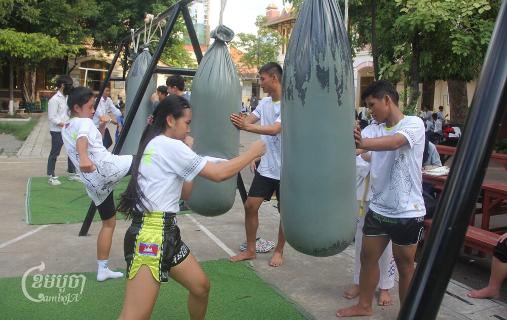 យុវតី សុវណ្ណ មាលា និងសិស្សផេ្សងទៀតនៃវិទ្យាល័យព្រះស៊ីសុវត្ថិ ហាត់ដាល់ និងទាត់បាវសាក់ កាលពីរសៀលថ្ងៃទី៦ ខែកក្កដា ឆ្នាំ២០២៤។ (ខេមបូចា/ ស៊ា បញ្ញា)
