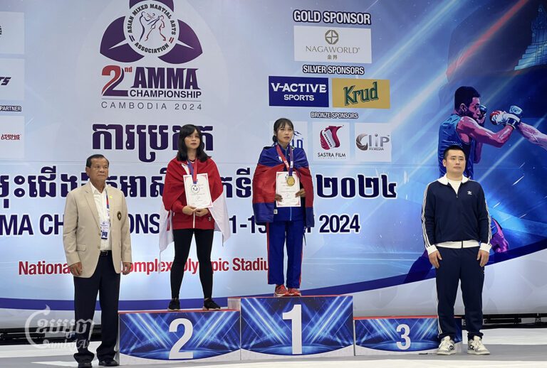 ម្ចាស់មេដាយមាសគុនចម្រុះរបស់កម្ពុជាក្នុងព្រឹត្តិការណ៍ AMMA កីឡាការិនី ខៀវ ចិន្តារ័ត្ន កំពុងឡើងទទួលមេដាយមាសទម្ងន់ក្រោម៤៩គីឡូក្រាម ក្រោយយកឈ្នះកីឡាការិនីឥណ្ឌូនេស៊ីនៅវគ្គផ្តាច់ព្រ័ត្រ។ រូបថតនៅពីថ្ងៃទី១៣ ខែកក្កដា ឆ្នាំ២០២៤។(ខេមបូចា/ ប៉ា តុងចិន)