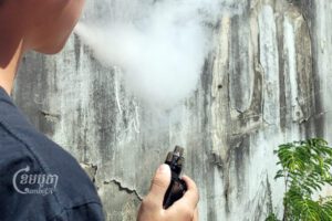 យុវជនម្នាក់កំពុងឈរជក់បារីអេឡិចត្រូនិក នៅក្នុងទីក្រុងភ្នំពេញ។ រូបថតនៅថ្ងៃទី២១ ខែធ្នូ ឆ្នាំ២០២២។ (ខេមបូចា/ ប៉ា តុងចិន)