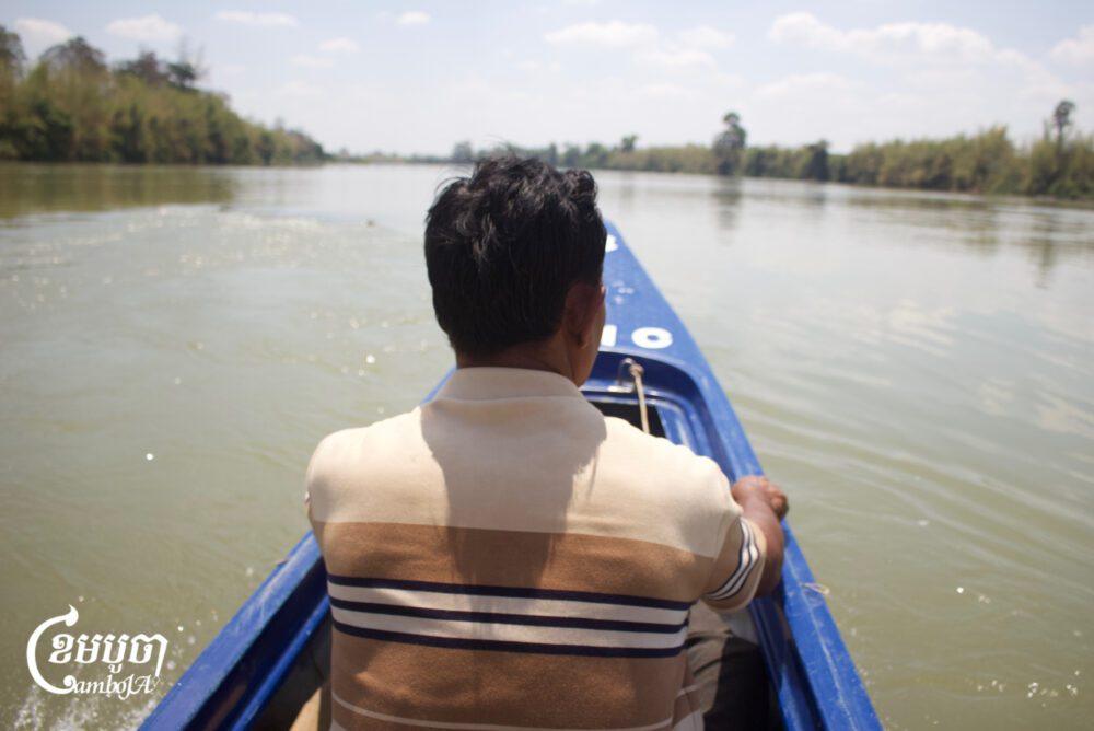 លោក ថា លែវ ពលរដ្ឋរស់នៅភូមិថ្មី ខេត្តរតនគិរី កំពុងជិះទូកតាមទន្លេស្រែពកទៅពិនិត្យគម្រោងសាងសង់ទំនប់វារីអគ្គិសនីស្រែពកក្រោម៣។ ថ្ងៃទី១៤ ខែមីនា ឆ្នាំ២០២៥។ (ខេមបូចា/Coby Hobbs)