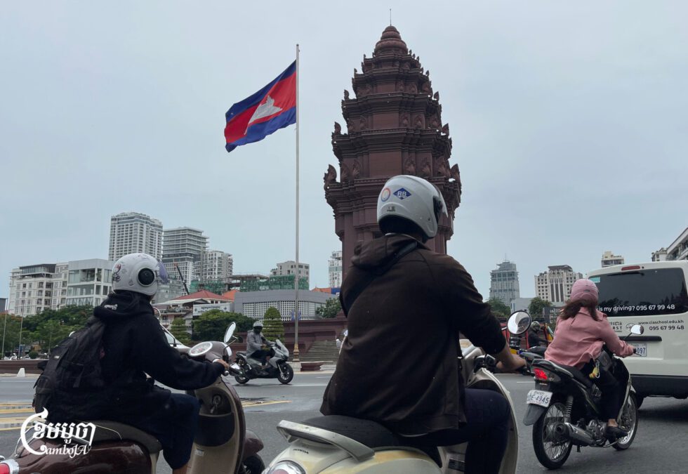 ពលរដ្ឋធ្វើដំណើរនៅរង្វង់មូលវិមានឯករាជ្យដែលមានដោតទង់ជាតិកម្ពុជា នាកណ្តាលរាជធានីភ្នំពេញ ថ្ងៃទី២១ ខែកក្កដា ឆ្នាំ២០២៥។ (ខេមបូចា/ព្រីង សំរាំង)
