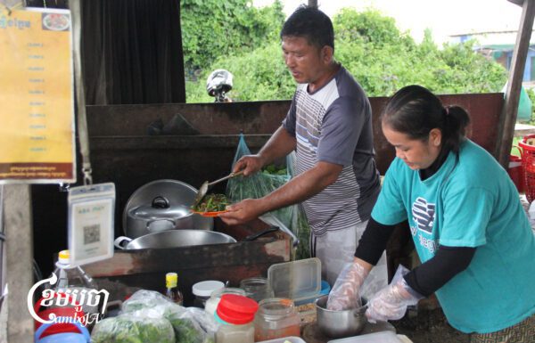 លោក ជាយ ពយ និងប្រពន្ធ ប៉ក់ ចន្ថា ធ្វើម្ហូបឱ្យភ្ញៀវ នៅក្នុងតូបលក់ ស្ថិតនៅតាមដងផ្លូវរថភ្លើង ក្បែរបុរីពិភពថ្មីឈូកវ៉ា២ ស្ថិតក្នុងសង្កាត់សំរោងក្រោម ខណ្ឌពោធិ៍សែនជ័យ រាជធានីភ្នំពេញ កាលពីថ្ងៃទី១៤ ខែកញ្ញា ឆ្នាំ២០២៥។ (ខេមបូចា/ ស៊ា បញ្ញា)