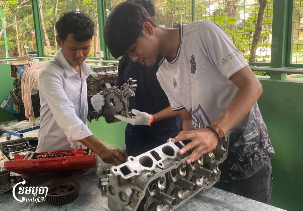 (រាប់ពីស្តាំ) អេង ពិសិដ្ឋ និងយុវជនផ្សេងទៀត នៅអគាររៀនជួសជុល និងថែទាំរថយន្តនៅវិទ្យាស្ថានបច្ចេកទេសឧស្សាហកម្ម កាលពីថ្ងៃទី១២ ខែវិច្ឆិកា ឆ្នាំ២០២៥​។ (ខេមបូចា/ វិសាល វិស្ណុ)